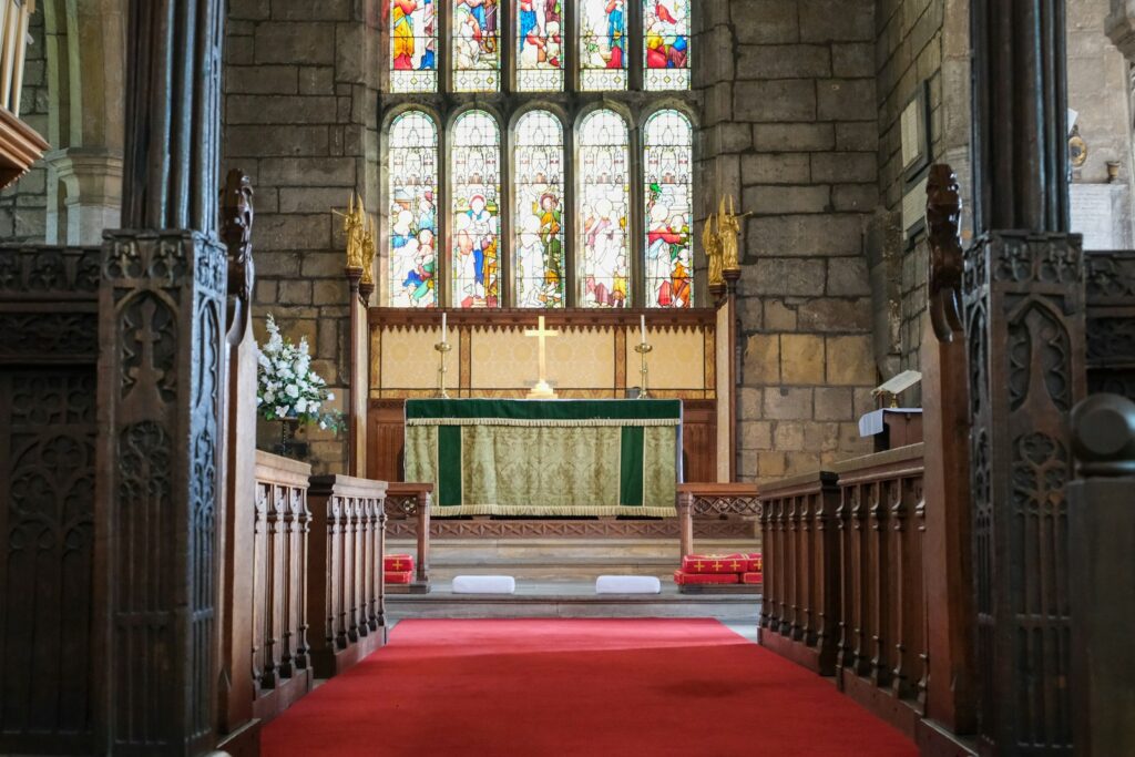 Interior de una iglesia con alfombra roja hasta el altar, preparada para una boda cristiana