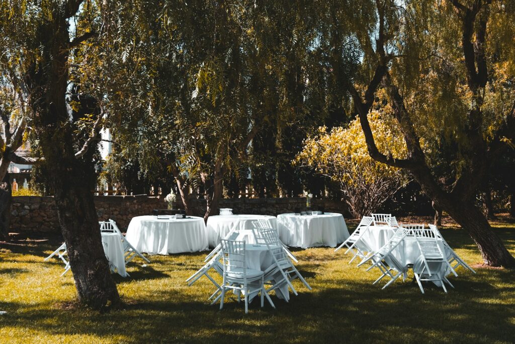 Mesas de banquete al aire libre bajo los árboles en el jardín de una finca (imagen ilustrativa)