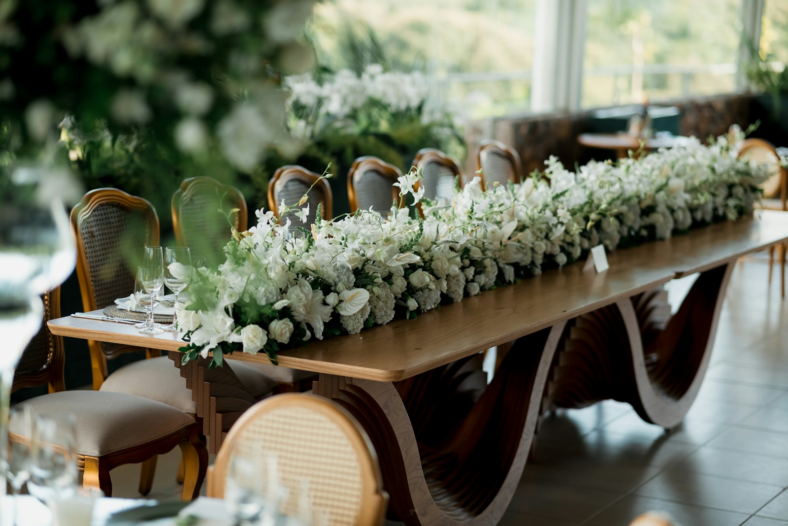Mesa imperial de madera sin mantel decorada con flores blancas